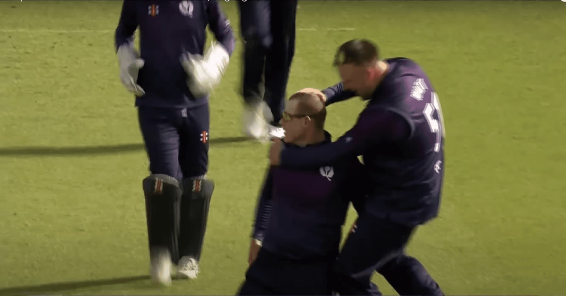 Scotland players embrace after taking a wicket